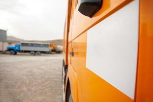 een detailopname van een oranje dump vrachtauto deur Bij een bouw plaats foto