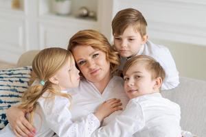 schattig kinderen knuffelen, opgewonden mam tonen liefde en affectie, glimlachen moeder foto