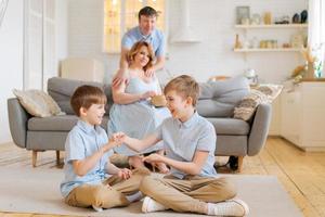 gelukkig familie besteden vrij tijd in leven kamer, jong ouders zijn ontspannende Aan sofa foto