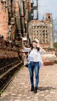 vrouw jong reiziger met rugzak selfies met vriend door mobiel in tempel ayutthaya Thailand, reizen vakantie ontspanning concept foto
