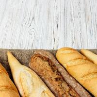 eigengemaakt stokbrood Aan houten tafel. dichtbij omhoog foto