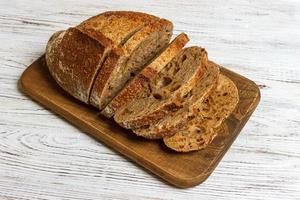 gesneden Frans brood Aan houten bord. wit houten achtergrond foto