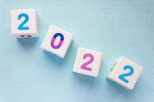 kubussen met kleurrijk getallen 2022 gelegen diagonaal Aan een blauw achtergrond. nieuw jaar, kalender. foto