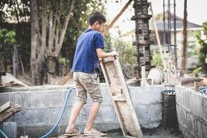 arme kinderen op de bouwplaats moesten werken. concept tegen kinderarbeid. de onderdrukking of intimidatie van dwangarbeid onder kinderen. mensenhandel. foto