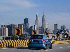 een klein blauw is het rijden haar manier in downtown Kuala lomp, Maleisië foto