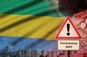 Gabon vlag en coronavirus 2019-ncov alarm teken. concept van hoog waarschijnlijkheid van roman coronavirus het uitbreken door op reis toeristen foto