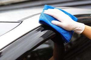 auto zorg arbeiders wassen, verstuiven en schoon de auto. foto