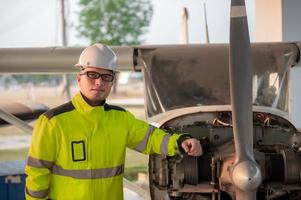 technicus vaststelling de motor van de vliegtuig, mannetje ruimtevaart bouwkunde controle vliegtuig motoren, aziatische monteur onderhoud inspecteert vlak motor foto