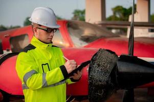 technicus vaststelling de motor van de vliegtuig, mannetje ruimtevaart bouwkunde controle vliegtuig motoren, aziatische monteur onderhoud inspecteert vlak motor foto