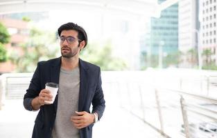 de bedrijf Mens Holding een kop van koffie en vervelend de gewoontjes pak terwijl haast je omhoog Gaan naar werk Bij de stormloop uur. foto