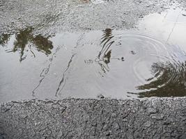 de middag lucht was weerspiegeld in een plas van water Aan de stoep. schot met reflector techniek gebruik makend van water foto