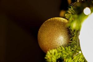 detailopname gouden Kerstmis ballen versierd Aan pijnboom boom Aan Kerstmis nacht Aan zwart achtergrond. foto