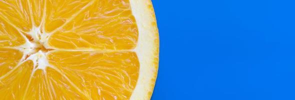 top visie van een een oranje fruit plak Aan helder achtergrond in blauw kleur. een verzadigd citrus structuur beeld foto