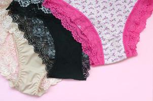 wit, zwart en roze Dames ondergoed met kant Aan roze achtergrond met kopiëren ruimte. reclame voor winkel van mooi en comfortabel Dames ondergoed foto