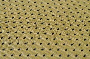 achtergrond beeld van een kleding stof structuur van een geel Jersey gemaakt van polyester nylon. macro foto met Ondiep diepte van veld-