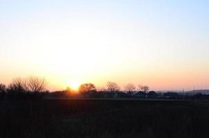 dageraad in de dorp. zonsopkomst in de buitenwijk landschap foto