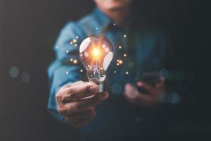 vernieuwend technologie in wetenschap en communicatie concepten, technologie creativiteit voor toekomst uitvindingen en ontwikkelingen, zaken voor vernieuwend oplossing concept, zakenman Holding een licht lamp foto