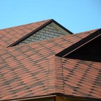 de dak is gedekt met bitumineus gordelroos van bruin kleur. kwaliteit dakbedekking foto