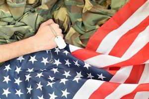 mannetje hand- houdt hond label Aan Verenigde Staten van Amerika vlag en leger uniform achtergrond foto