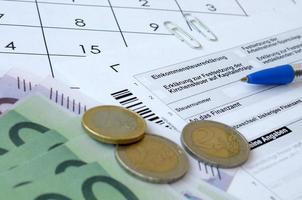 Duitse belasting het formulier met pen en Europese geld rekeningen leugens Aan kantoor kalender. belastingbetalers in Duitsland gebruik makend van euro valuta naar betalen belastingen foto