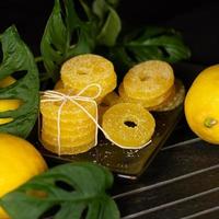 citroen, oranje en grapefruit plakjes in suiker geïsoleerd Aan een houten achtergrond, detailopname. marmelade snoepgoed. snoepgoed met citrus smaak. snoepjes foto