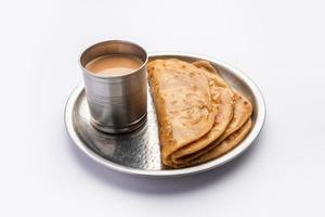 chai paratha - heet thee geserveerd met flatbread is een traditioneel gemakkelijk maaltijd van Indië en Pakistan foto