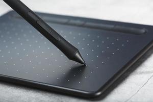 grafisch tablet met een pen werken ontwerper, detailopname. apparaatje voor creativiteit en werk van een fotograaf, illustrator en kunst artiest. foto