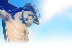 Jezus Christus Aan de kruis tegen een achtergrond van blauw lucht foto