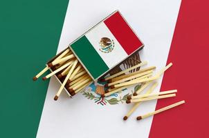 Mexico vlag is getoond Aan een Open luciferdoosje, van welke meerdere wedstrijden vallen en leugens Aan een groot vlag foto