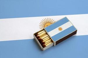 Argentinië vlag is getoond in een Open luciferdoosje, welke is gevulde met wedstrijden en leugens Aan een groot vlag foto