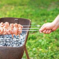 handen van Mens bereidt zich voor barbecue vlees foto