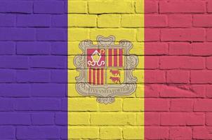 Andorra vlag afgebeeld in verf kleuren Aan oud steen muur. getextureerde banier Aan groot steen muur metselwerk achtergrond foto