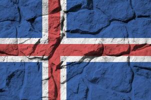 IJsland vlag afgebeeld in verf kleuren Aan oud steen muur detailopname. getextureerde banier Aan rots muur achtergrond foto