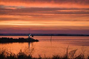zonsondergang in Zweden Bij de haven van meer vaetern. vuurtoren in de achtergrond foto