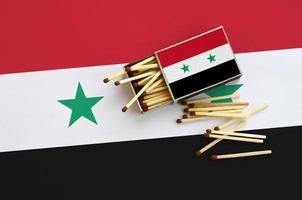 Syrië vlag is getoond Aan een Open luciferdoosje, van welke meerdere wedstrijden vallen en leugens Aan een groot vlag foto