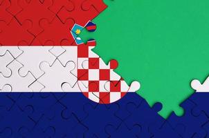 Kroatië vlag is afgebeeld Aan een voltooid decoupeerzaag puzzel met vrij groen kopiëren ruimte Aan de Rechtsaf kant foto