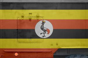 Oeganda vlag afgebeeld Aan kant een deel van leger gepantserd vrachtauto detailopname. leger krachten conceptuele achtergrond foto