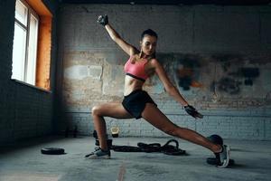 fit jong vrouw op zoek geconcentreerd terwijl oefenen in Sportschool foto