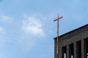top van een kerk met een roestig metaal kruis, de kerk is gemaakt van steen met Doorzichtig blauw lucht. Mexico foto