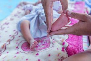 ouders handen Holding klein pasgeboren baby meisje voeten. foto