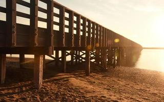 zon glinsterend uit duxbury baai met een brug foto