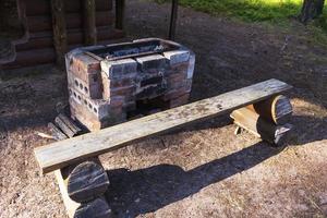 oud steen barbecue barbecue in de achtertuin in de zomer, een bank voor buitenshuis recreatie foto