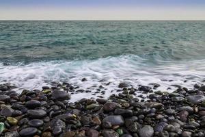 stenen kust van de oceaan met golven foto