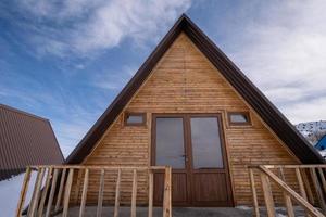 de detailopname houten huisjes omringd door sneeuw. een recreatie Oppervlakte in de bergen foto