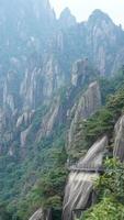 de mooi bergen landschappen met de groen Woud en een plank weg gebouwd langs de gezicht van een klif in de platteland van de China foto