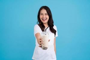 Aziatisch meisje Holding een kop van parel melk thee met een glimlach, pret en geluk foto