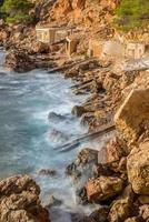 cala salada en saladeta in san antonio een slechte Bij Balearen eilanden Spanje. lang blootstelling, typisch huis voor visvangst boten en rotsen. foto