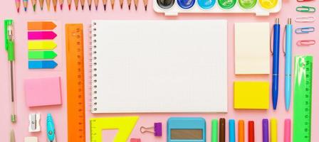 school- benodigdheden, schrijfbehoeften Aan roze achtergrond. pennen potloden kladblok. vlak leggen foto