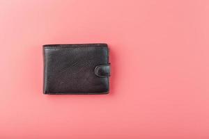 zwart portemonnee Aan roze achtergrond. symbool van welvaart en voorspoed. foto