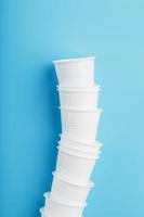 plastic cups van beschikbaar serviesgoed in de vorm van een toren Aan een blauw achtergrond. foto